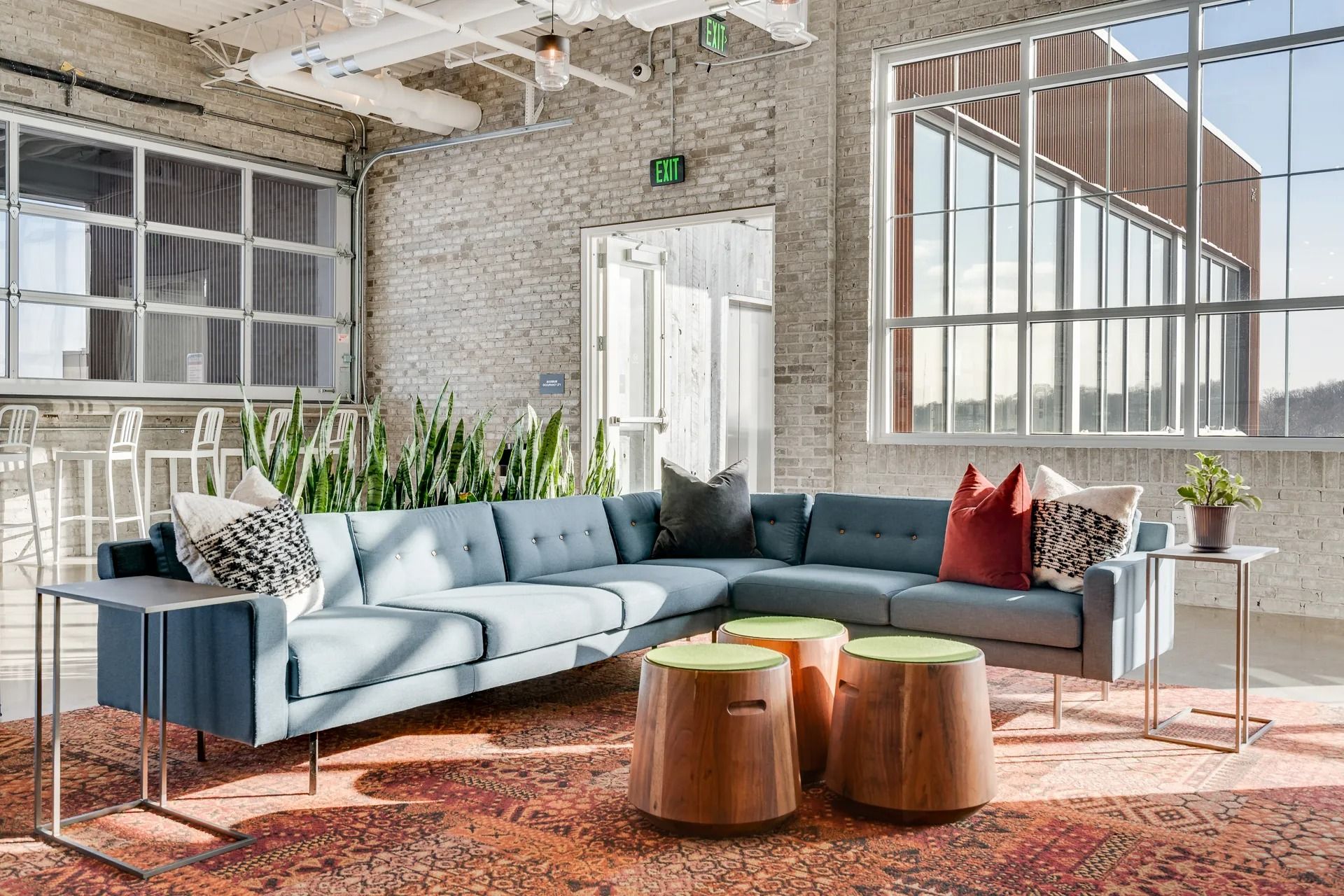 Large couch with pillows inside community rooftop amenity area at Max Apartments