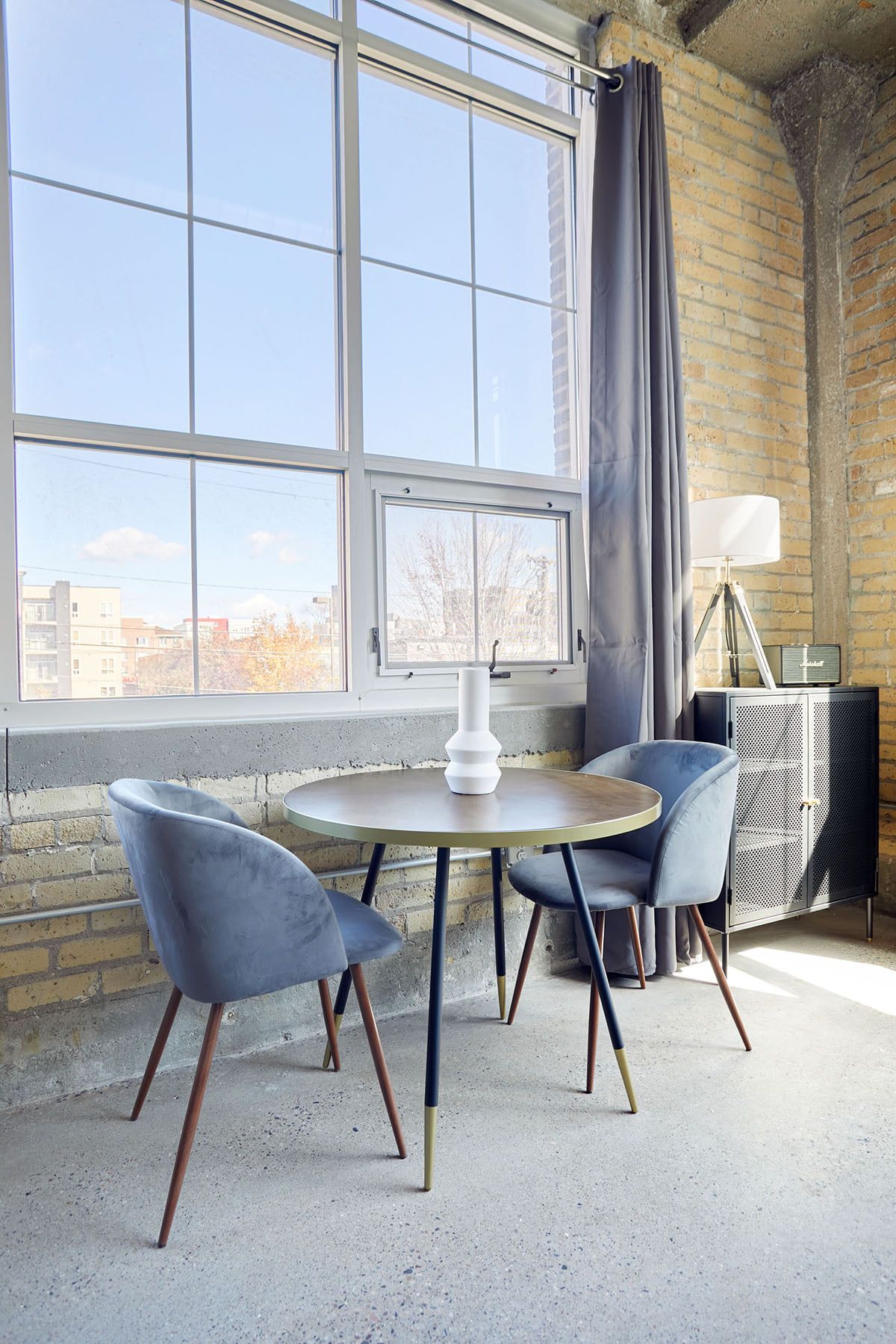 Small dining table with two chairs in front of Minneapolis apartment window