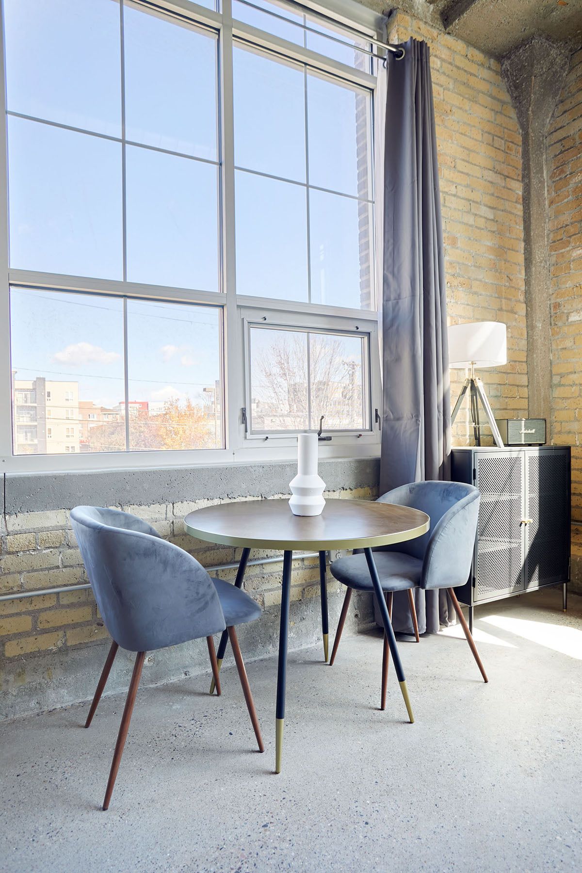 Small dining table with two chairs in front of Minneapolis apartment window