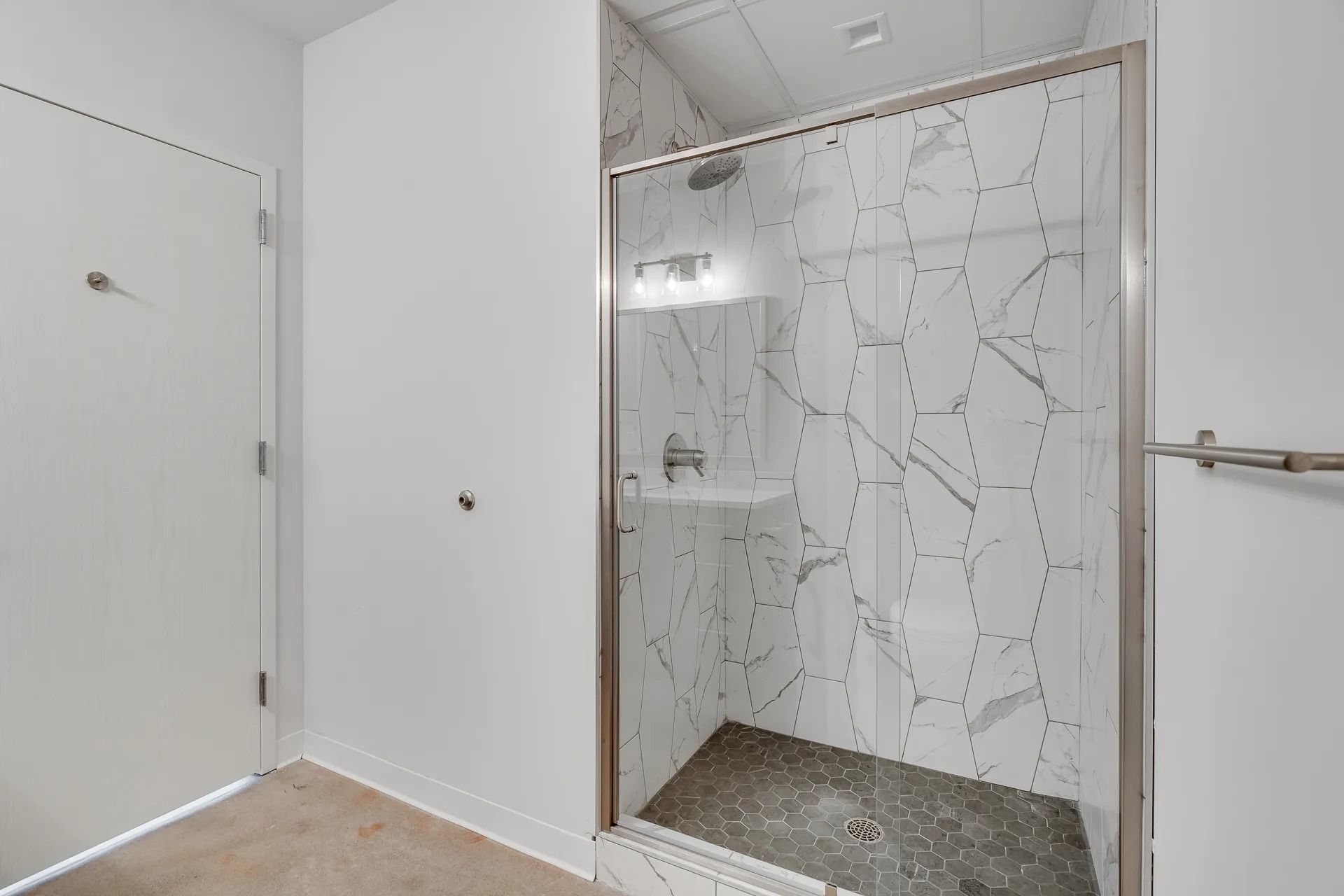 Glass enclosed shower with beautiful tile inside MAX apartments for graduate students and University of Minnesota faculty